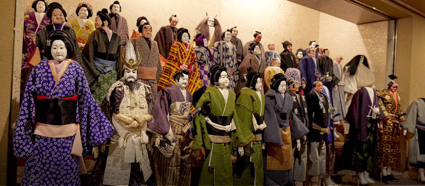 楽屋の廊下の一角に、出番を待つ人形たちが並ぶ。主役級の登場人物は幕によって衣裳やかしらが変わる。