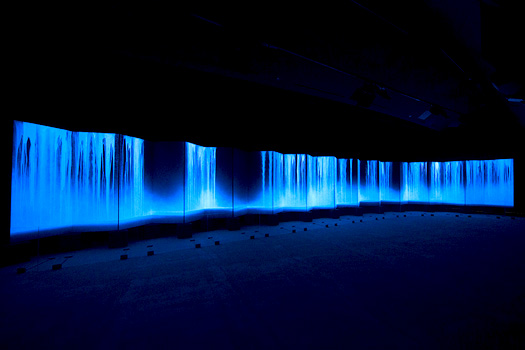 2015年のヴェネツィア・ビエンナーレで特別展示された24ｍの大作「Ryujin（龍神）Ⅰ･Ⅱ」。蛍光塗料で描いた滝が、ブラックライトの光に照らされ、月光の中の滝そののもののように青白く光る。